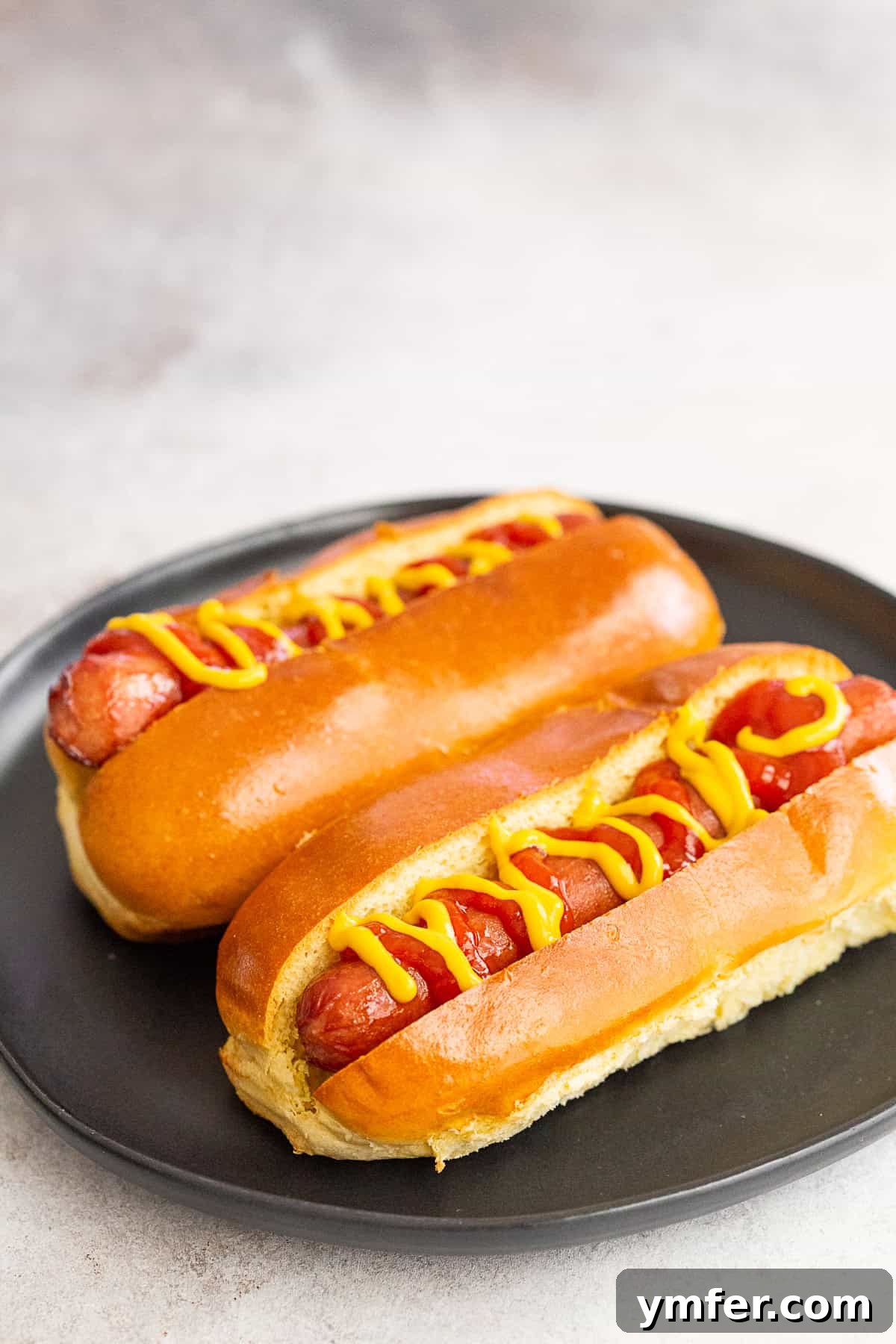 Two air fryer hot dogs on a plate.
