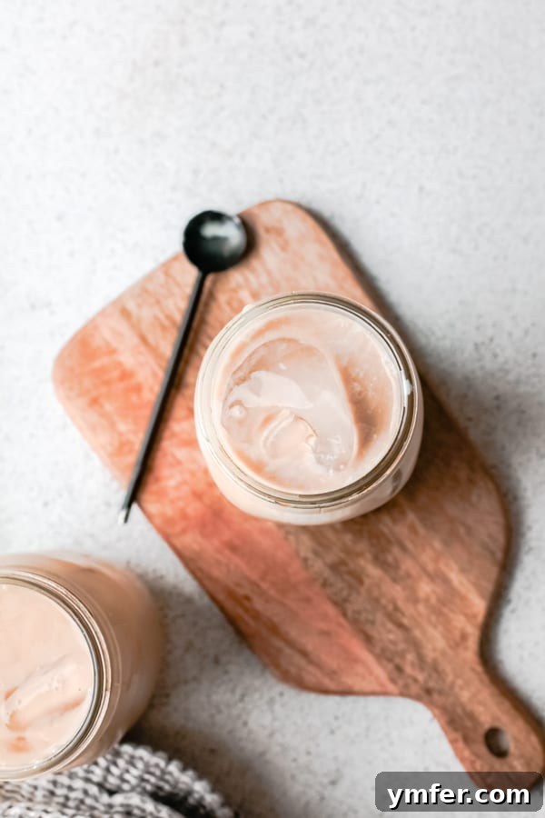 Golden Brown Sugar Shaken Espresso 3 Close-up of Iced Brown Sugar Oat Milk Shaken Espresso with a straw, showcasing its layers.
