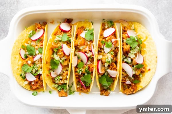 Golden Baked Ground Chicken Tacos 3 Close-up of baked ground chicken tacos in a baking dish