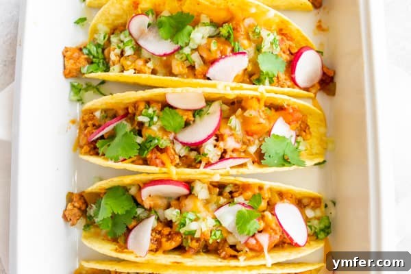 Golden Baked Ground Chicken Tacos 7 A serving of three baked ground chicken tacos on a plate