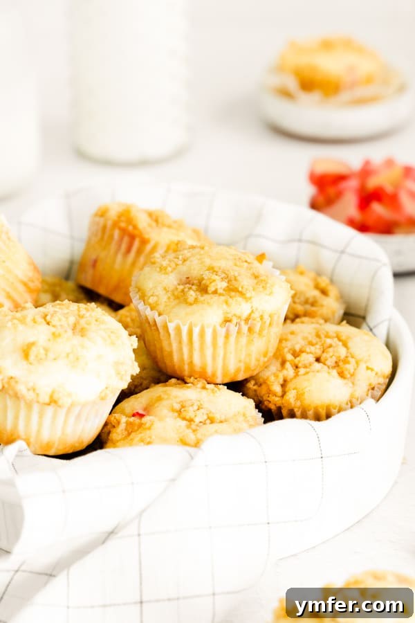 Rhubarb Crumble Muffins 6 A charming basket filled with several warm, streusel topped rhubarb muffins, ready to be enjoyed.