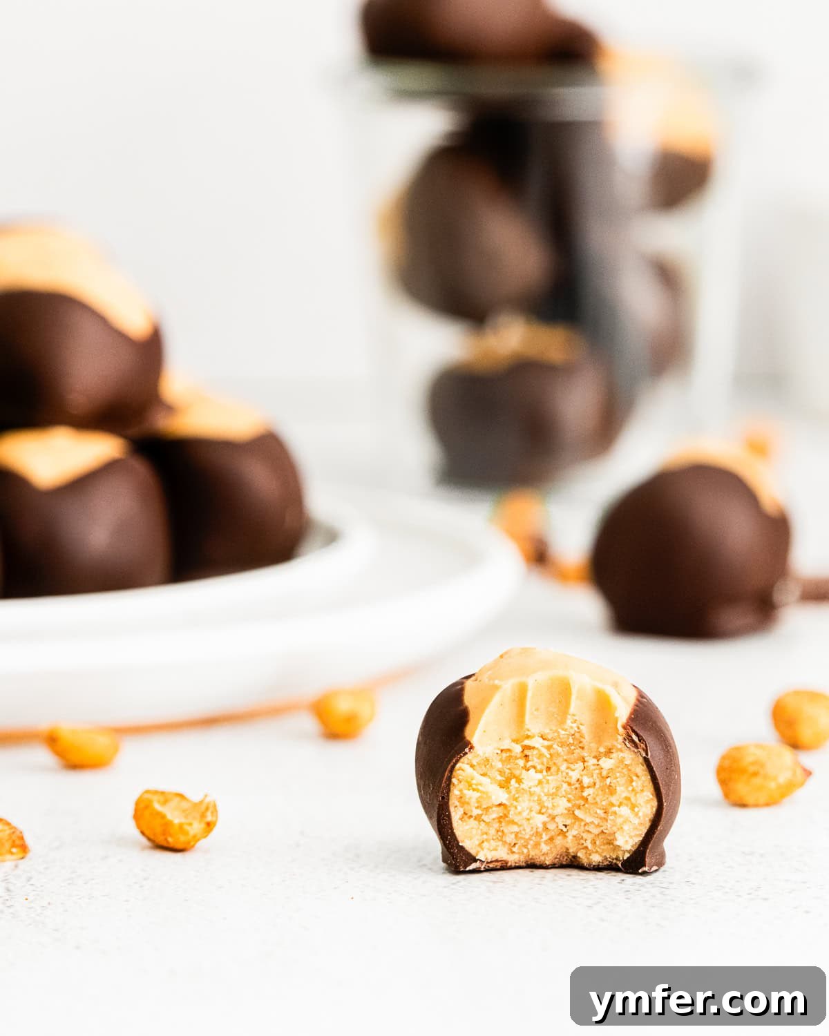 Ultimate Peanut Butter Buckeyes 8 A single peanut butter buckeye with a bite taken out, resting on a small white plate