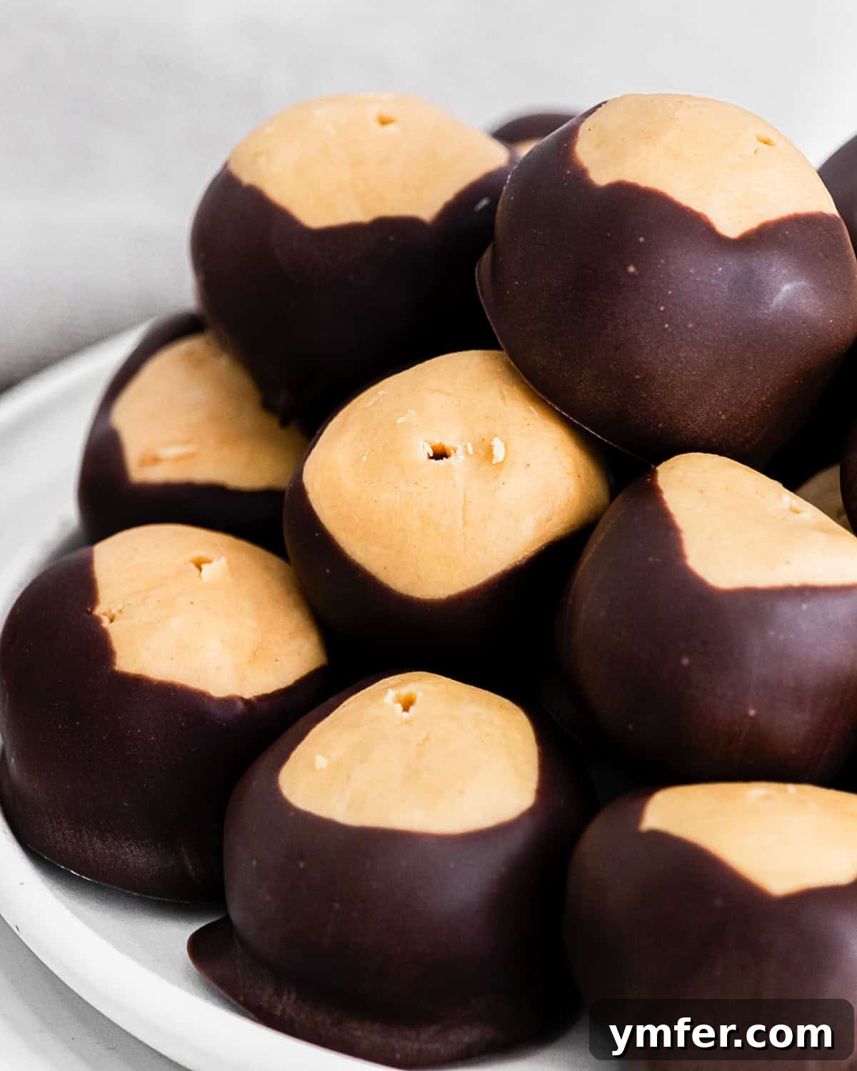Ultimate Peanut Butter Buckeyes 9 A close-up of a perfectly dipped peanut butter buckeye, highlighting its smooth chocolate coating and exposed peanut butter top