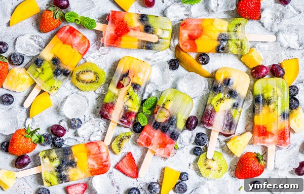 A beautifully presented serving tray with multiple homemade Rainbow Fruit Popsicles on ice, garnished with an abundance of fresh fruit, highlighting their vibrant appeal.