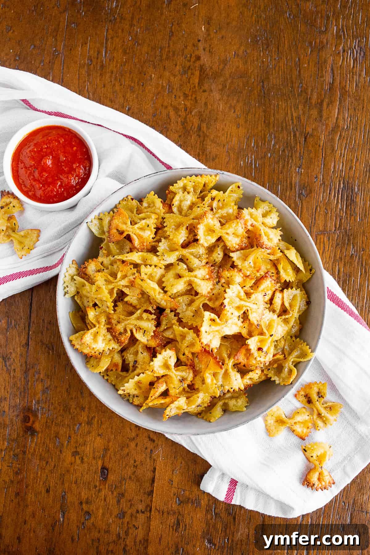 Crispy Air Fryer Pasta Chips 2 Air fryer pasta chips in a bowl with a side of marinara sauce for dipping.
