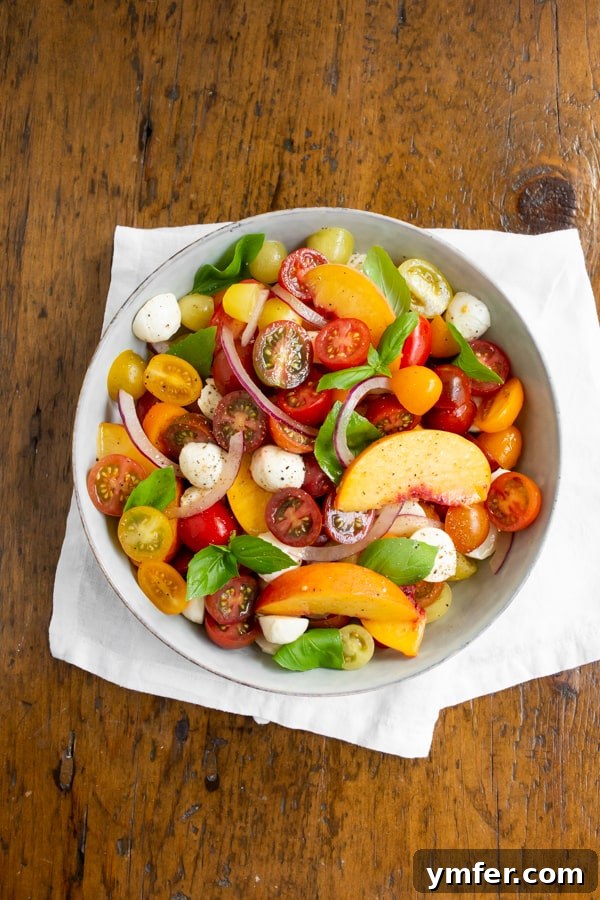 Sun-Kissed Peach Tomato Caprese 4 Tomato Peach Caprese Salad in a bowl sitting on a white napkin.
