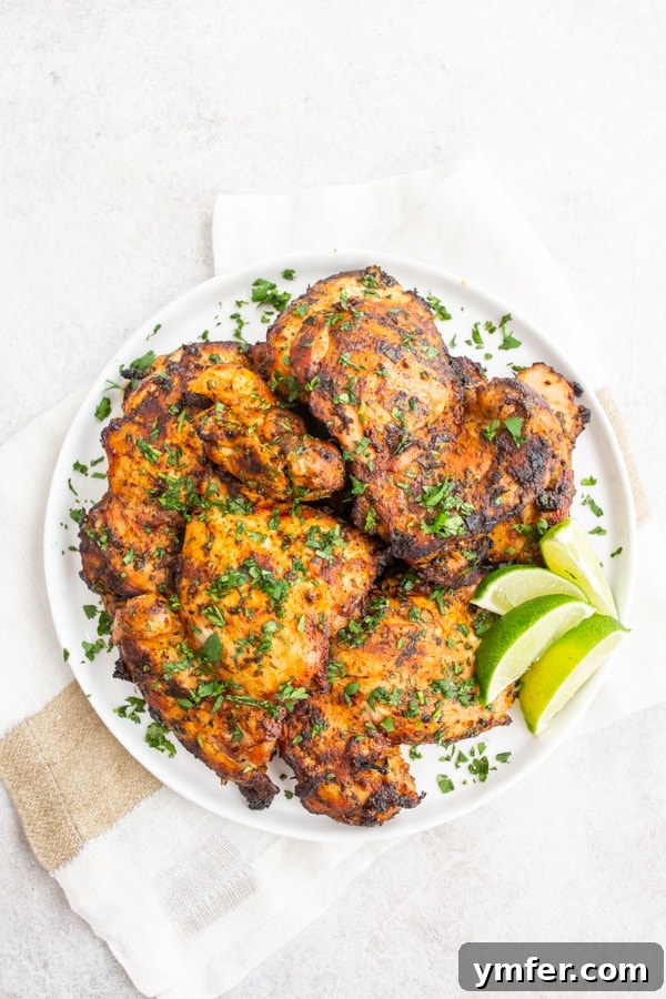 Bright Cilantro Lime Grilled Chicken Thighs 2 Grilled Cilantro Lime Chicken Thighs served on a plate with cilantro and lime wedges.
