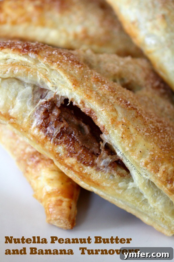Golden-brown Nutella Peanut Butter Banana Turnovers arranged on a baking sheet, ready to be enjoyed.