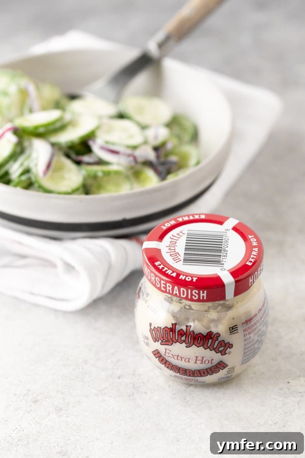 Cool Cucumber Salad with Creamy Horseradish 5 a jar of horseradish sauce sitting in front of a bowl of creamy horseradish cucumber salad.