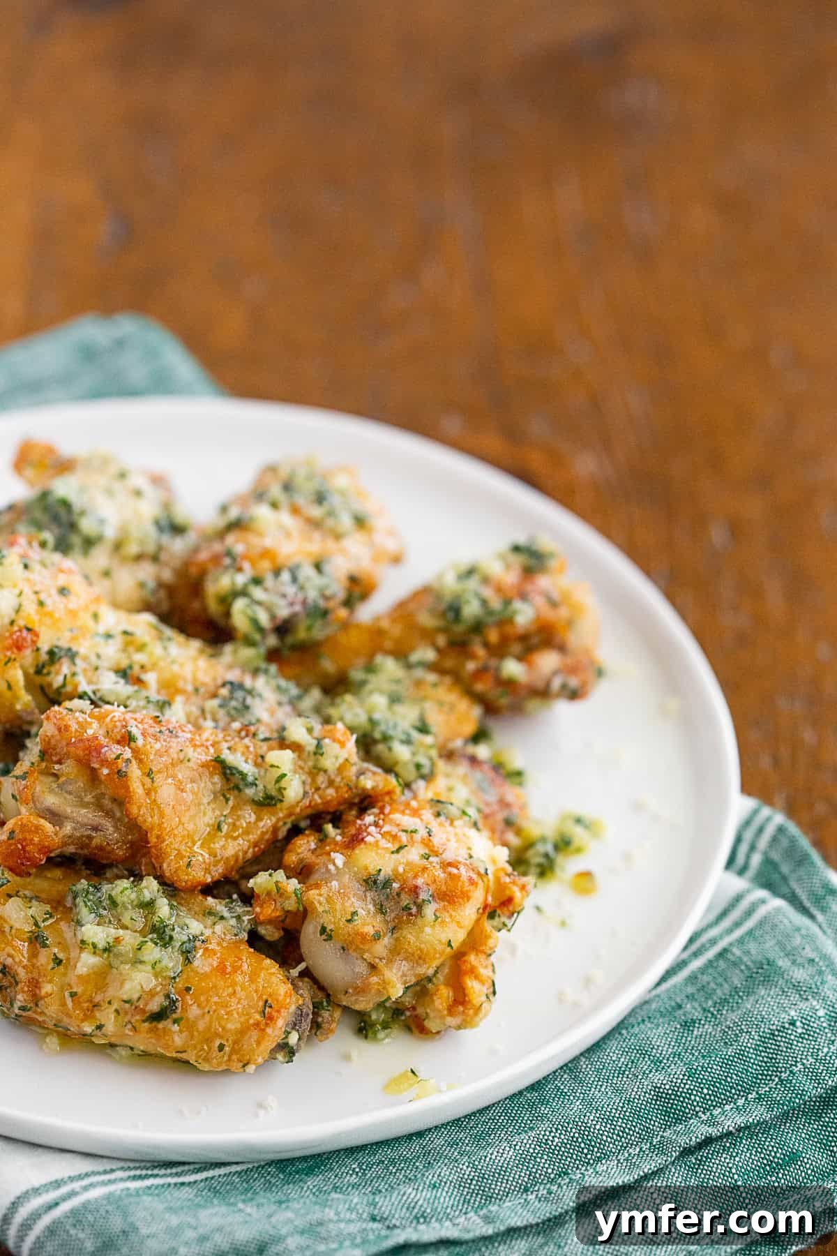 Crispy Air Fryer Garlic Parmesan Wings 3 Garlic Parmesan Chicken Wings covered in sauce.