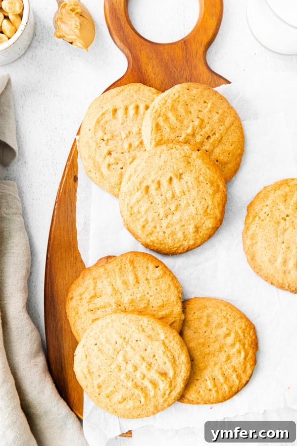 Ultimate Brown Butter Peanut Butter Cookies 5 Warm Brown Butter Peanut Butter Cookies resting on parchment paper on a wire rack, cooling down and ready to be stored.
