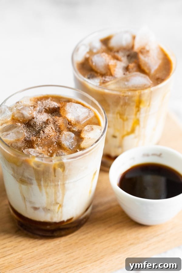 Spiced Apple Crisp Macchiato 2 A perfectly prepared Apple Crisp Macchiato, garnished and ready to be enjoyed on a wooden platter.
