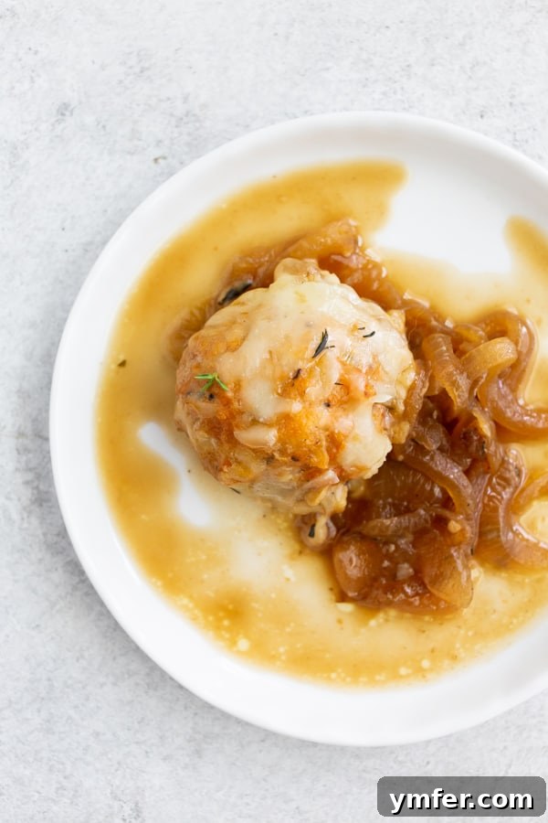 French Onion Chicken Meatballs served elegantly on a white plate, highlighting the golden-brown cheese and rich sauce. A truly appetizing display.