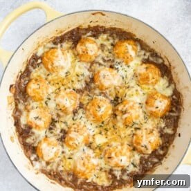 A top-down view of French Onion Chicken Meatballs in a baking dish, topped with melted cheese, ready to be served.