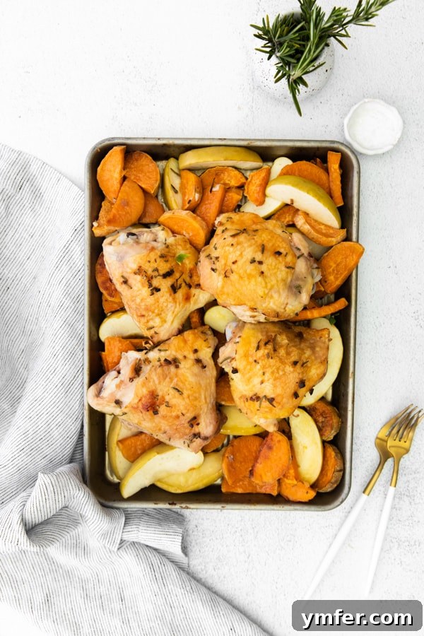 Sheet Pan Apple and Chicken Roast 2 Crispy Sheet Pan Chicken and Apples with Sweet Potatoes, freshly roasted and served on the sheet pan, garnished with herbs.