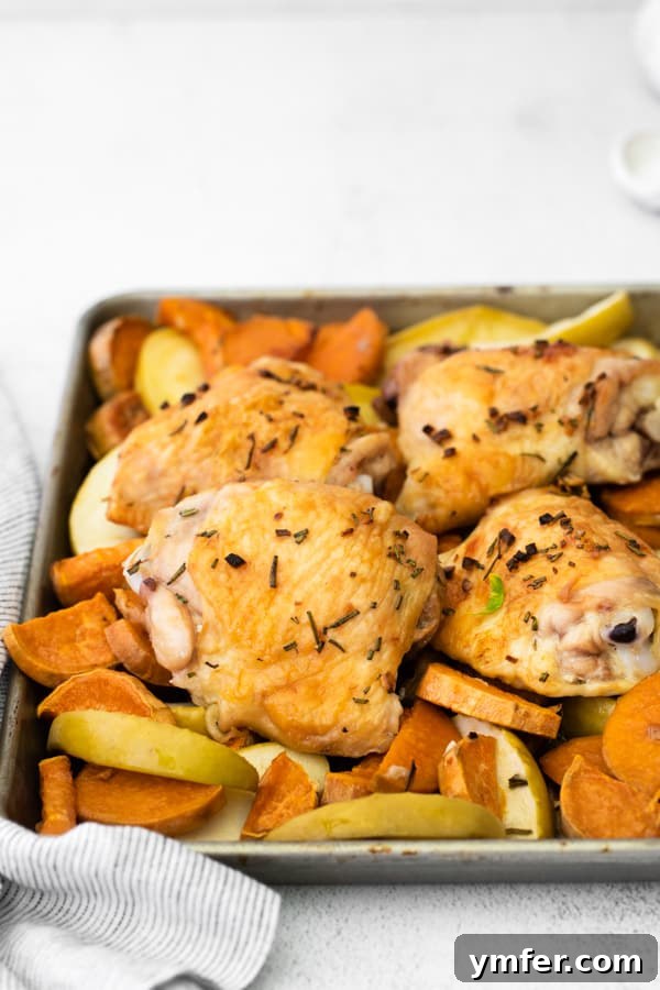 Sheet Pan Apple and Chicken Roast 4 Sheet Pan Chicken and Apples and Sweet Potatoes on a baking sheet, sprinkled generously with fresh rosemary before baking.