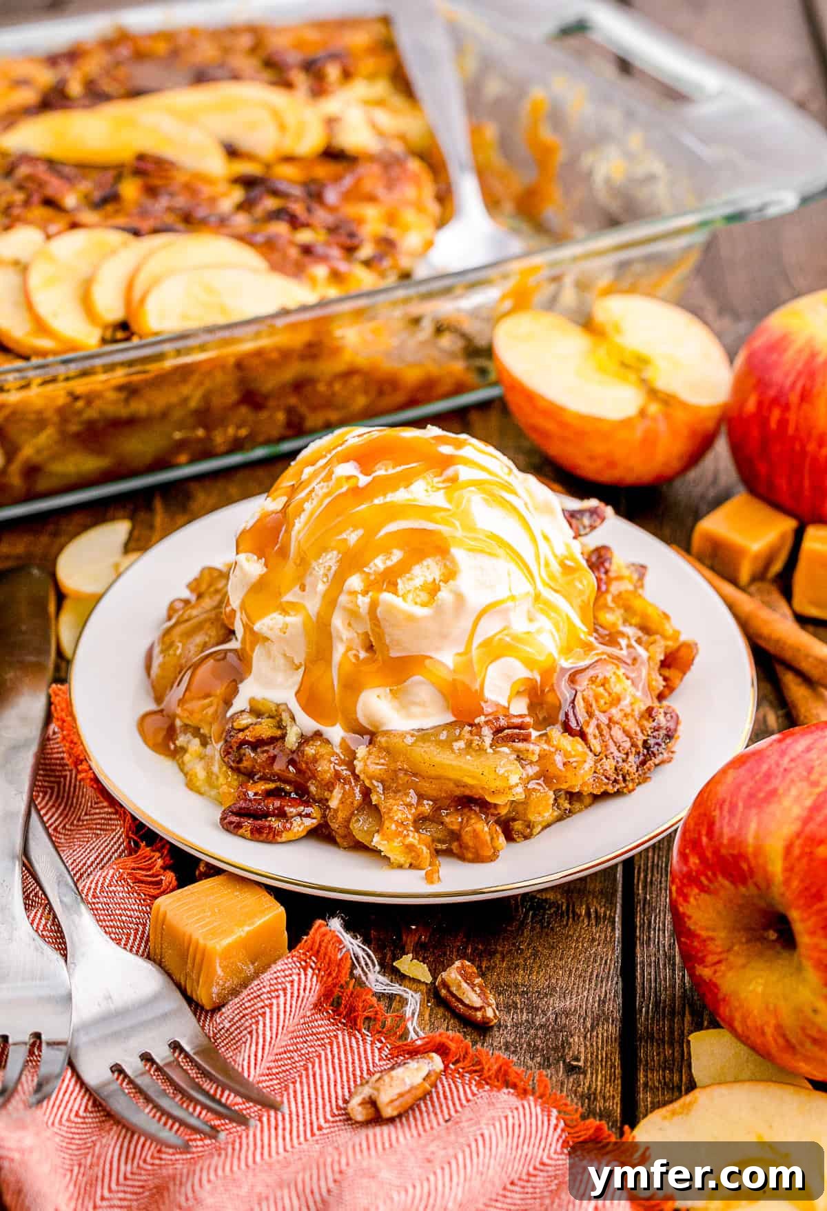 Golden Caramel Apple Bake 3 A serving of Caramel Apple Dump Cake topped with a scoop of vanilla ice cream and drizzled with extra caramel sauce, highlighting its warm, inviting appeal.