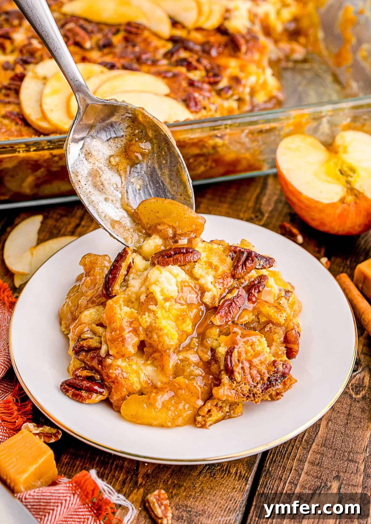 Golden Caramel Apple Bake 6 A spoon scooping a generous portion of warm Caramel Apple Dump Cake onto a plate, showcasing the gooey caramel and tender apples.