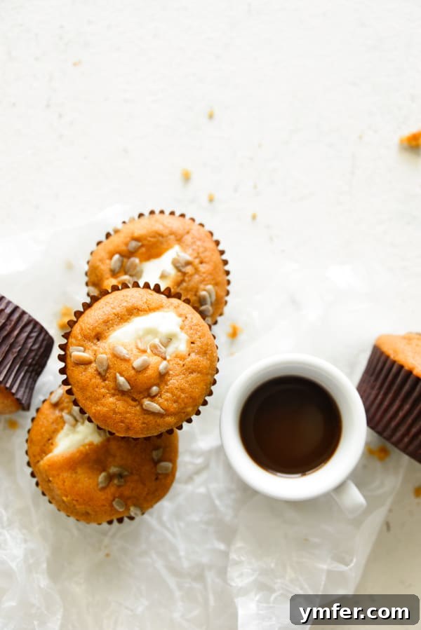 Heavenly Pumpkin Cream Cheese Swirls 6 Pumpkin Cream Cheese Muffins served with a cup of coffee.