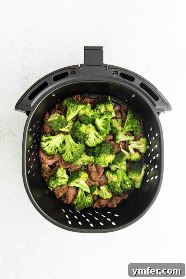 Crispy Air Fryer Beef and Broccoli 3 Air Fryer Beef and Broccoli in the air fryer basket.