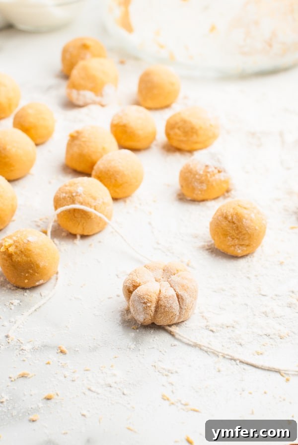 Autumn Pumpkin Gnocchi Pillows 5 A hand demonstrating how to shape pumpkin gnocchi using a toothpick to create ridges.