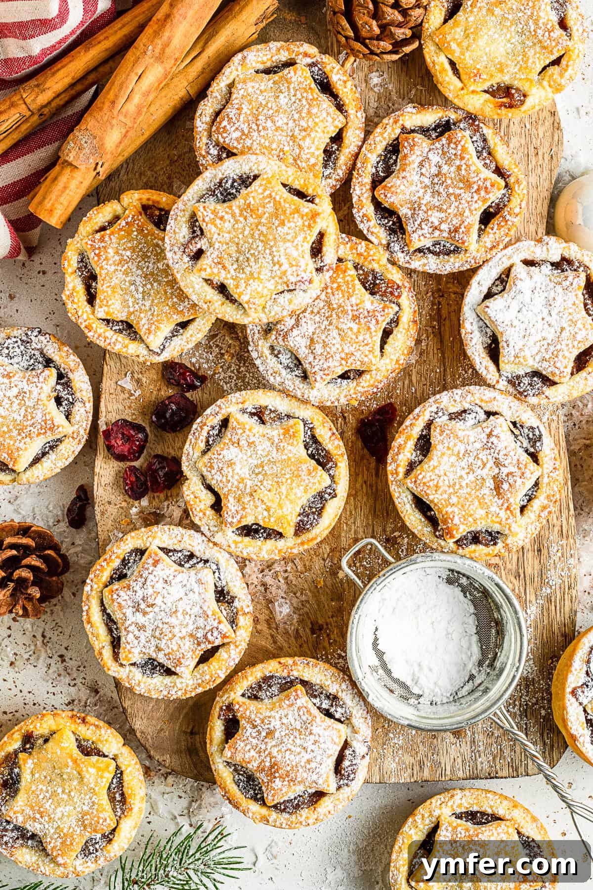 Spiced Holiday Mini Tarts 4 Mini Mincemeat Pies on a board with powdered sugar.