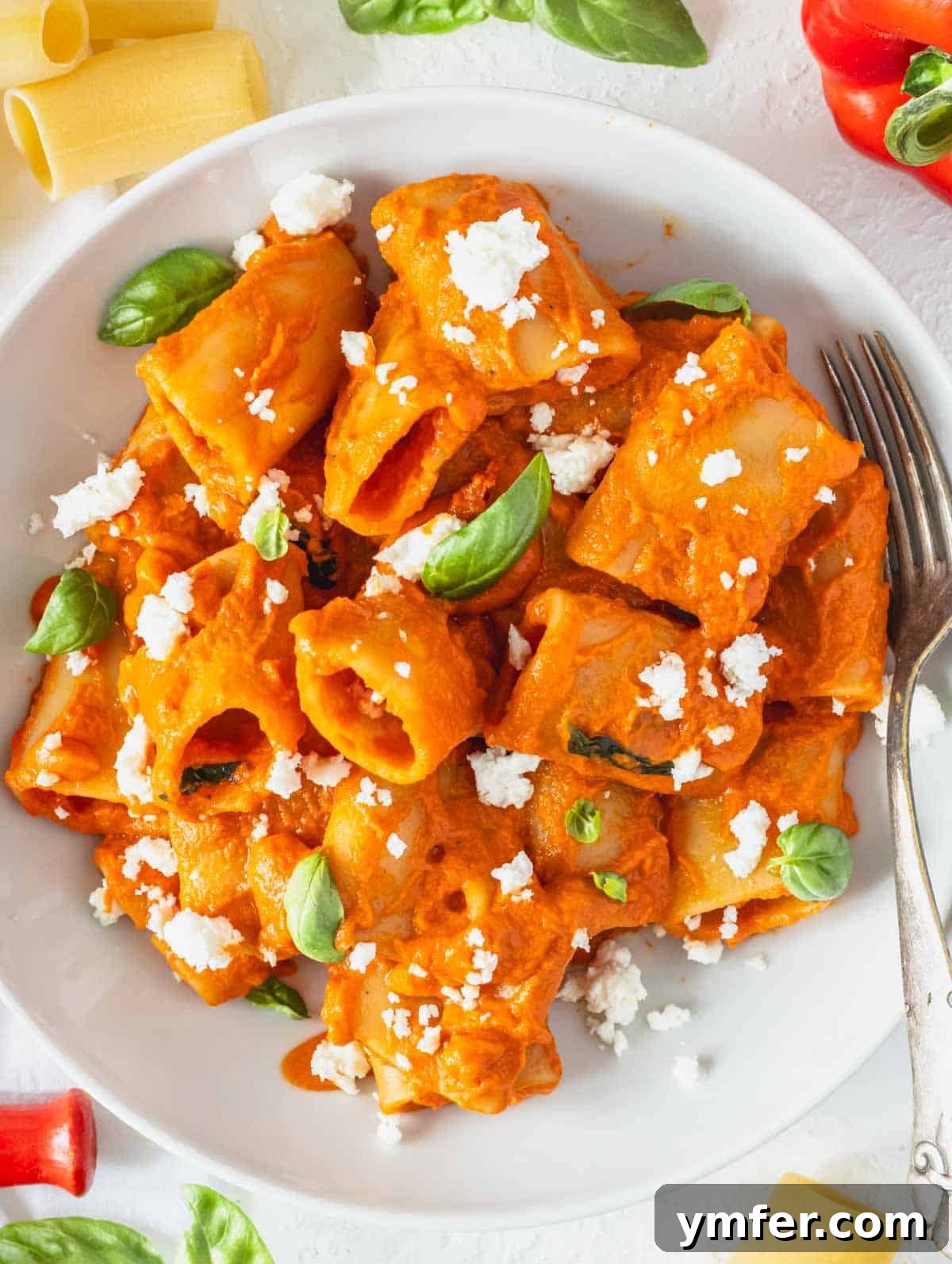Plant-Powered Pasta 2 High protein pasta with feta crumble and fresh basil leaves in a white bowl