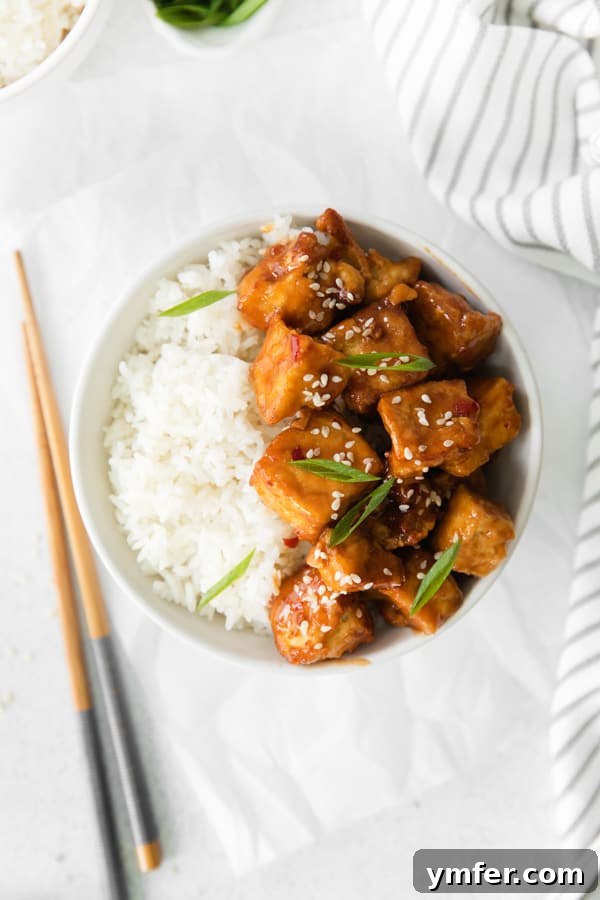 Crispy Sweet Chili Air Fryer Tofu 2 Air Fryer Sweet Chili Tofu in a white bowl served over rice, garnished with green onions.