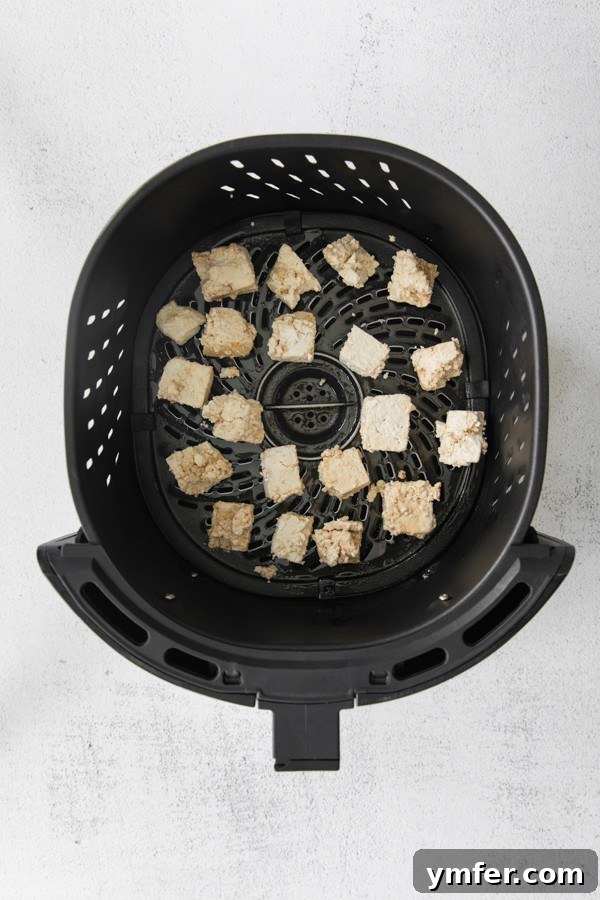 Crispy Sweet Chili Air Fryer Tofu 4 Marinated tofu cubes coated in cornstarch, ready for the air fryer.