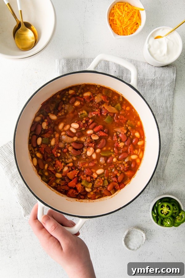 Hearty Vegan Lentil Chili 5 Vegan Lentil Chili served in a large white Dutch oven, ready to be enjoyed.