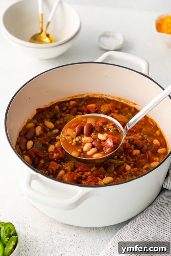 Hearty Vegan Lentil Chili 6 A Dutch oven filled with simmering Vegan Lentil Chili on a stovetop.
