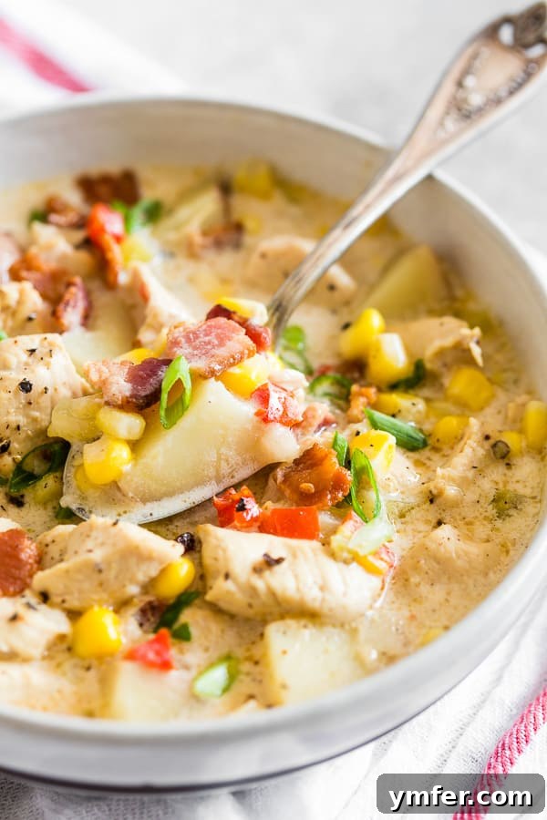 Homestyle Chicken Corn Chowder 3 Close-up of Chicken Corn Chowder in a rustic bowl with a spoon, showing the creamy texture and chunks of ingredients.