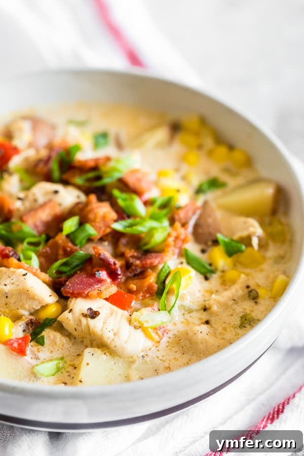 Homestyle Chicken Corn Chowder 5 A beautifully presented bowl of Chicken Corn Chowder, garnished with fresh green onions and crispy bacon, ready to be served.