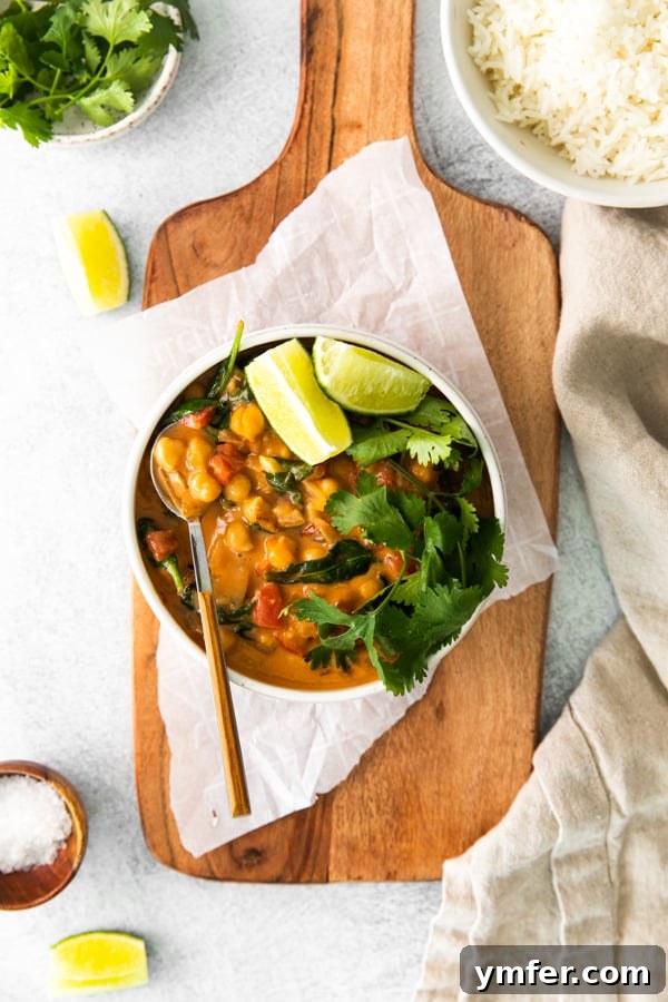 Hearty Vegan Chickpea Curry 6 Vegan Chickpea Curry served in a bowl, garnished with cilantro and a lime wedge.