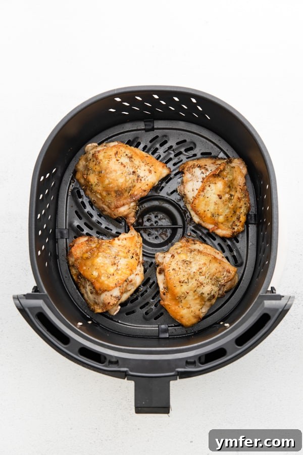 Ultimate Air Fryer Chicken Thighs 3 Air Fryer Chicken Thighs in a the air fryer basket.
