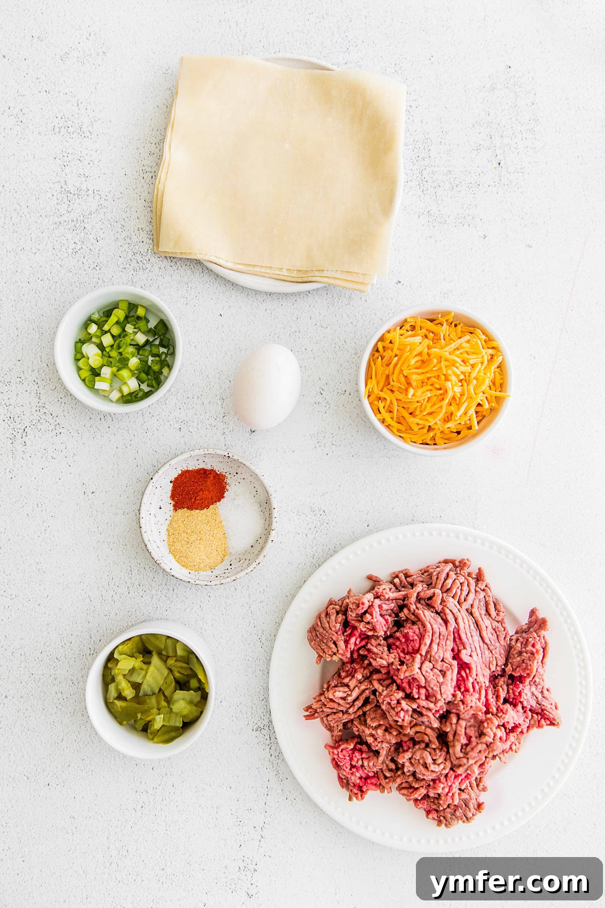 Crispy Air Fryer Cheeseburger Rolls 3 Air Fryer Cheeseburger Egg Roll ingredients on a table.