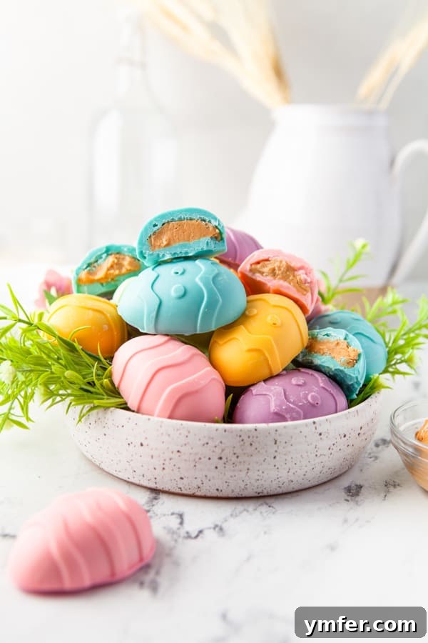Decadent Peanut Butter Eggs 3 Peanut Butter Eggs served in a stone bowl, showcasing their smooth, colorful coating and perfect egg shape. Ideal for Easter dessert tables.