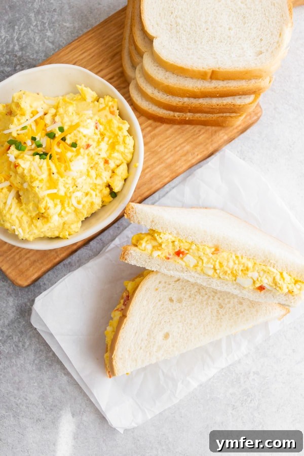 Creamy Pimento and Cheddar Egg Salad 2 Pimento Cheese Egg Salad served on white soft bread.