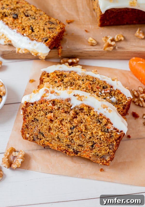 Spiced Carrot Loaf 2 A perfectly sliced Carrot Cake Loaf Cake on parchment paper, revealing its moist interior and generous frosting.