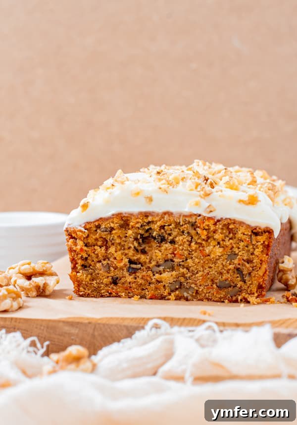 Spiced Carrot Loaf 3 Close-up view of a sliced Carrot Cake Loaf Cake, showcasing its texture and the delicious cream cheese frosting.