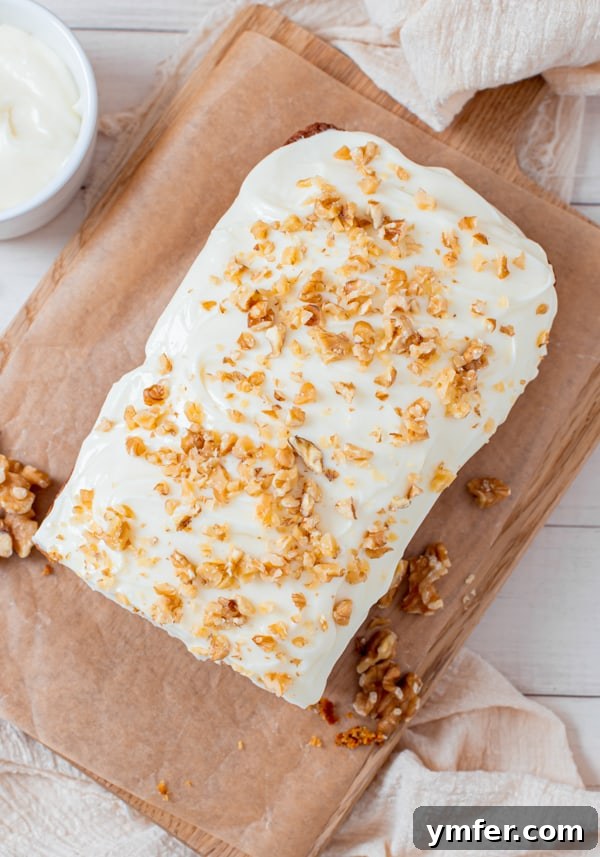 Spiced Carrot Loaf 5 A fully frosted Carrot Cake Loaf Cake topped with chopped walnuts, ready to be served.