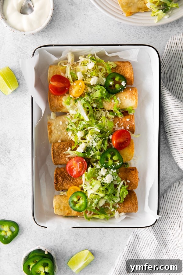 Crispy Air Fryer Chicken Taquitos 2 Air Fryer Chicken Taquitos served in a dish, garnished with fresh toppings.