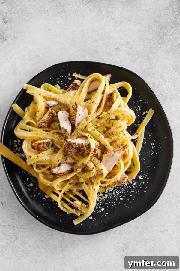Ultimate Chicken Fettuccine Alfredo 6 Chicken Fettuccine Alfredo served on a plate with a fork.