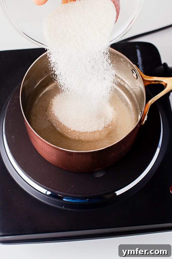 Garden Mint Elixir 3 Pouring sugar into water in a saucepan to make mint simple syrup.