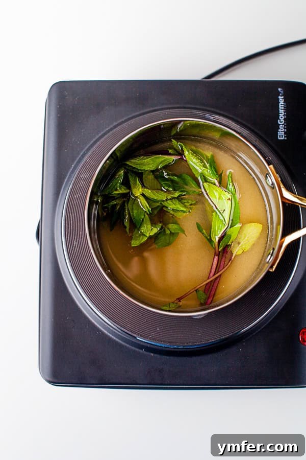 Garden Mint Elixir 4 Fresh mint sprigs and sugar being combined in a pot with water to make mint simple syrup.