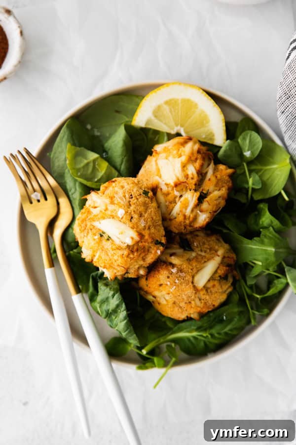 Crispy Air-Fried Crab Cakes 2 Crispy Air Fryer Crab Cakes served on a plate with fresh lemon wedges.