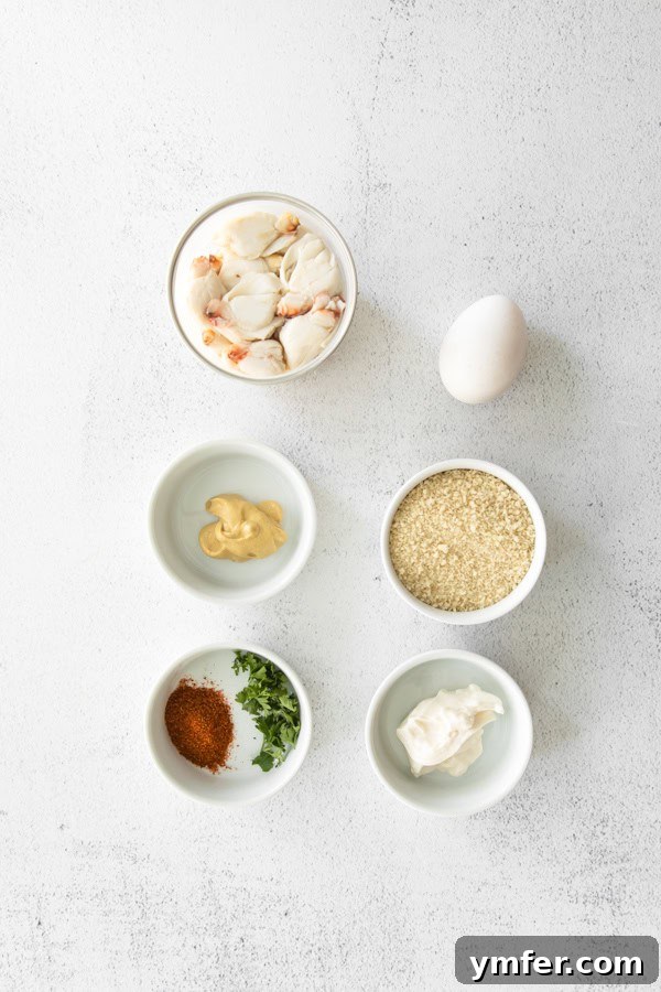 Crispy Air-Fried Crab Cakes 3 Fresh ingredients laid out for making Air Fryer Crab Cakes: egg, mayonnaise, Dijon mustard, panko breadcrumbs, Old Bay seasoning, parsley, and lump crab meat.