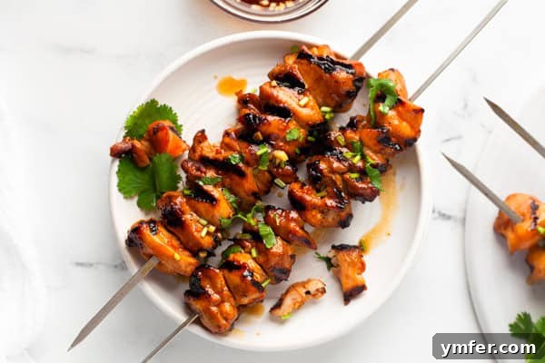 Sweet Heat Chicken Kebabs 7 Hot Honey Chicken Skewers on a white plate.