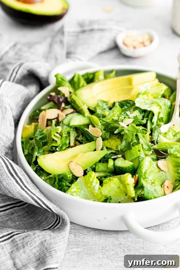 Divine Green Goddess Salad 6 A close-up shot of Green Goddess Salad garnished with perfectly sliced avocado and crunchy almonds, emphasizing its fresh ingredients.