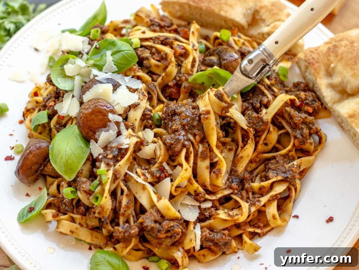 Rich Fungi Ragout 12 mushroom bolognese with a fork and parmesan cheese
